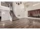 Bright living room featuring wood floors, high ceilings, a staircase, and modern light fixtures at 45105 W Horse Mesa Rd, Maricopa, AZ 85139