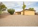 Large backyard with gravel landscaping, mature trees, and a covered patio for relaxing and entertaining at 4701 E Voltaire Ave, Phoenix, AZ 85032