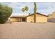 Spacious backyard featuring a covered patio, mature trees, and desert landscaping, perfect for outdoor living at 4701 E Voltaire Ave, Phoenix, AZ 85032