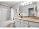 This bathroom features white cabinets and a shower and tub combo with a shower curtain at 4705 E Betty Elyse Ln, Phoenix, AZ 85032