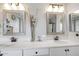 Bathroom with a double sink vanity featuring framed mirrors, stylish lighting, and white countertops at 4705 E Betty Elyse Ln, Phoenix, AZ 85032