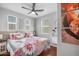 Cozy bedroom with a floral patterned quilt, decorative wall art, a ceiling fan, and window blinds at 4705 E Betty Elyse Ln, Phoenix, AZ 85032