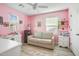 This bedroom features pink walls, hardwood floors, and modern white furnishings at 4705 E Betty Elyse Ln, Phoenix, AZ 85032