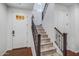 Entryway with a wooden staircase featuring metal banisters and a front door with glass panels at 4705 E Betty Elyse Ln, Phoenix, AZ 85032