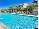 Community pool area features ample seating and shaded pergolas on a sunny day at 4705 E Betty Elyse Ln, Phoenix, AZ 85032