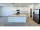 Open kitchen boasting a central island, modern appliances, and sleek white cabinetry at 47248 W Cansados Rd, Maricopa, AZ 85139