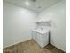 Functional laundry room featuring a washer, dryer, shelving, and practical tiled flooring at 47248 W Cansados Rd, Maricopa, AZ 85139