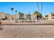 A welcoming view of El Chaparral community, complemented by desert landscaping and tall palm trees against a bright blue sky at 4950 N Miller Rd # 240, Scottsdale, AZ 85251