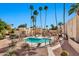 Community pool and spa surrounded by palm trees, desert landscaping, and fencing at 4950 N Miller Rd # 240, Scottsdale, AZ 85251