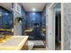 Stylish bathroom featuring a blue tiled shower, gold fixtures, and a modern vanity at 5137 E Flower St, Phoenix, AZ 85018