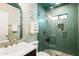 Stylish bathroom featuring green tile, glass shower, and brushed metal fixtures at 5137 E Flower St, Phoenix, AZ 85018