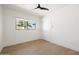 Bright bedroom features wood floors, a ceiling fan, and a window with outdoor views at 5137 E Flower St, Phoenix, AZ 85018