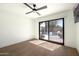 Minimalist bedroom with hardwood floors and sliding glass door leading to a backyard pool at 5137 E Flower St, Phoenix, AZ 85018