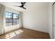 This bright bedroom features wood floors, a modern ceiling fan, and stylish curtains at 5137 E Flower St, Phoenix, AZ 85018