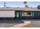 Charming single story home with a teal front door and shutters along with black brick and a stone walkway at 5137 E Flower St, Phoenix, AZ 85018