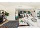 Bright, open-concept living room flowing into the kitchen, complete with sleek white furnishings and modern decor at 5137 E Flower St, Phoenix, AZ 85018