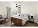 Serene main bedroom with a wooden bed, hardwood floors, a leather chair, and a large window at 5137 E Flower St, Phoenix, AZ 85018