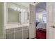 Well-lit bathroom with large mirror over the vanity, and doorway to main bedroom at 5230 E Brown Rd # C117, Mesa, AZ 85205