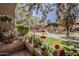 Charming courtyard view with vibrant flowers, a hummingbird feeder, and relaxing pergola space at 5230 E Brown Rd # C117, Mesa, AZ 85205