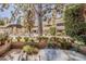 Inviting outdoor patio offering a view of mature trees, a community pergola, and verdant landscaping at 5230 E Brown Rd # 117, Mesa, AZ 85205