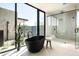 Modern bathroom featuring a stand-alone tub, walk-in shower and large picture window at 5287 N Invergordon Rd, Paradise Valley, AZ 85253