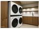 A full sized stacked washer and dryer with shelving and countertops at 5287 N Invergordon Rd, Paradise Valley, AZ 85253