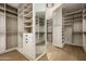 Spacious walk-in closet featuring custom shelving and hardwood floors at 5287 N Invergordon Rd, Paradise Valley, AZ 85253