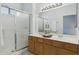 Bathroom featuring a double sink vanity with wood cabinets and shower with glass doors at 6050 S Crosscreek Ct, Chandler, AZ 85249