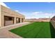 Expansive backyard featuring lush artificial turf, a covered patio, and a relaxing hot tub area at 61 S 111Th Pl, Mesa, AZ 85208