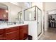 Bright bathroom featuring double sinks, a glass-enclosed shower, and a walk-in closet for convenience at 8304 E Inca St, Mesa, AZ 85207