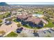 Aerial view of the community clubhouse with a pool, parking lot, well manicured lawn and lush landscaping at 8304 E Inca St, Mesa, AZ 85207