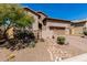 Charming home featuring desert landscaping, stone accents, a paver driveway, and a two-car garage at 8304 E Inca St, Mesa, AZ 85207