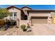 Charming home featuring desert landscaping, stone accents, a paver driveway, and a two-car garage at 8304 E Inca St, Mesa, AZ 85207