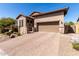 Home exterior showcasing a paver driveway, desert landscaping, and a two-car garage at 8304 E Inca St, Mesa, AZ 85207