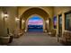 Exterior view of covered walkway with stone archway, decorative lighting, wooden benches and potted plants at 8304 E Inca St, Mesa, AZ 85207