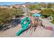 Aerial view of community playground with a green slide and multiple play structures in a desert landscape at 8304 E Inca St, Mesa, AZ 85207