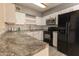 Modern kitchen with white cabinets, stainless steel appliances, gray countertops, and subway tile backsplash at 913 N Trekell Rd, Casa Grande, AZ 85122