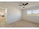 Bright bedroom with wood-look floors, a ceiling fan and a large window at 9305 W Calle Lejos --, Peoria, AZ 85383