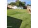 The backyard showcases a well-maintained synthetic turf lawn, complemented by mature trees at 934 S Evangeline Ave, Mesa, AZ 85208