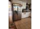 Kitchen with stainless steel refrigerator, white cabinets, and light-colored tile flooring at 934 S Evangeline Ave, Mesa, AZ 85208