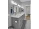 A modern bathroom with a double sink vanity and ample lighting with an adjacent door at 9477 W Tonopah Dr, Peoria, AZ 85382