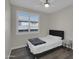 Bedroom with light gray walls, wood laminate flooring, ceiling fan and window with natural light at 9477 W Tonopah Dr, Peoria, AZ 85382