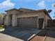 Single-story home featuring a two-car garage, desert landscaping, and easy-to-maintain yard at 9477 W Tonopah Dr, Peoria, AZ 85382