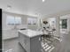 Contemporary kitchen featuring white cabinets, an island, and seamless transition to the living area at 9477 W Tonopah Dr, Peoria, AZ 85382