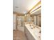 Well-lit bathroom featuring double sinks, a bathtub with a glass enclosure and tile floors at 10218 N 12Th Pl # 2, Phoenix, AZ 85020