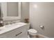 Stylish powder room with a white vanity, marble countertop, and decorative mirror at 10322 E Topaz Ave, Mesa, AZ 85212