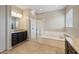 Bright main bathroom with a walk-in shower, soaking tub, dark cabinets, and granite countertops at 10322 E Topaz Ave, Mesa, AZ 85212