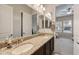 Double vanity bathroom with granite countertops, large mirrors, and modern lighting fixtures at 10322 E Topaz Ave, Mesa, AZ 85212