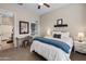 Charming bedroom with a comfortable bed, desk, bedside table, neutral color scheme, and carpet flooring at 10322 E Topaz Ave, Mesa, AZ 85212