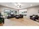 Comfortable living room with neutral carpet, ceiling fan, and natural light, open to the kitchen area at 10322 E Topaz Ave, Mesa, AZ 85212